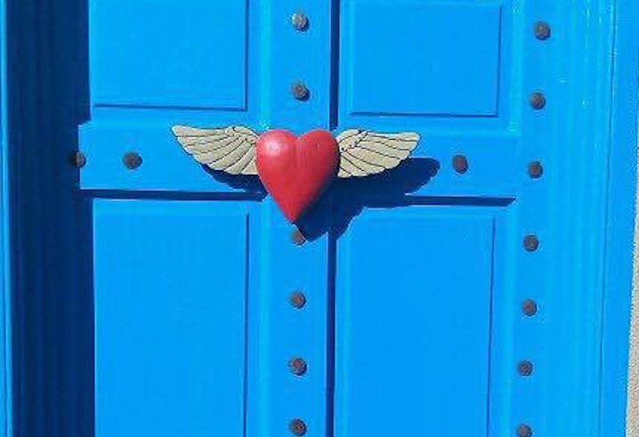 Life insurance and taxes | Photo of a red heart with wings on a blue door | Photo by Rita Pouppirt