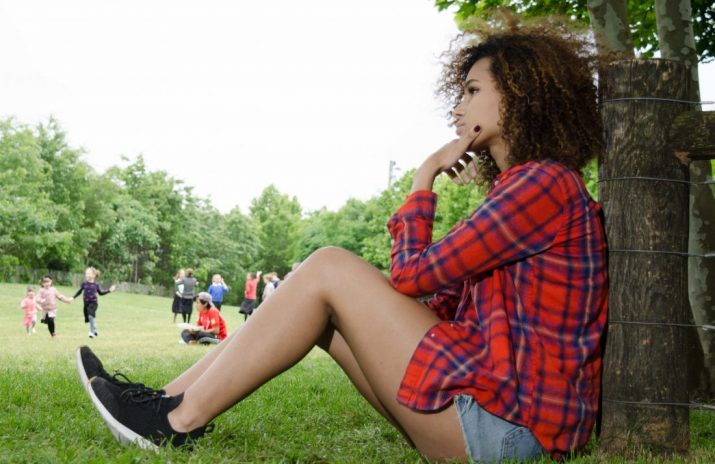 Women and Debt: A Feminist Issue? Women and Debt: A Feminist Issue? | Photo of a young woman sitting on a lawn and thinking | Photo by Eric Strausman