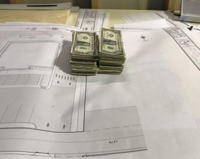 What is a certificate of deposit? How do CDs work? | Photo of money sitting on a blueprint | Photo by Rita Pouppirt