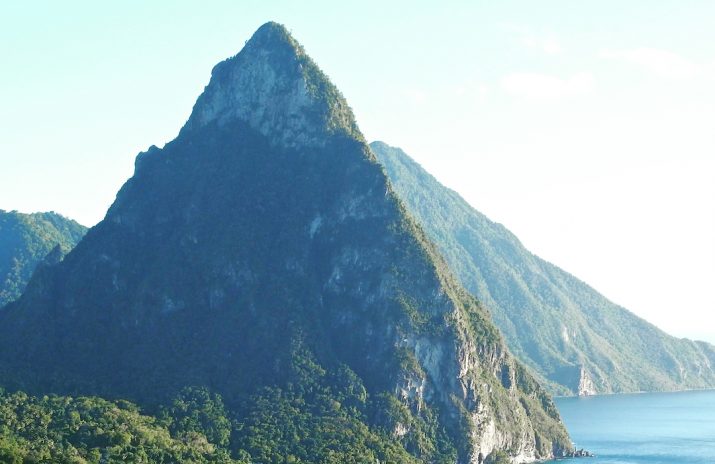Living Abroad Can Save You Money — Here’s How Living Abroad Can Save You Money — Here’s How | Photo of forested mountains and the sea with boads | Photo by Jeff Encke